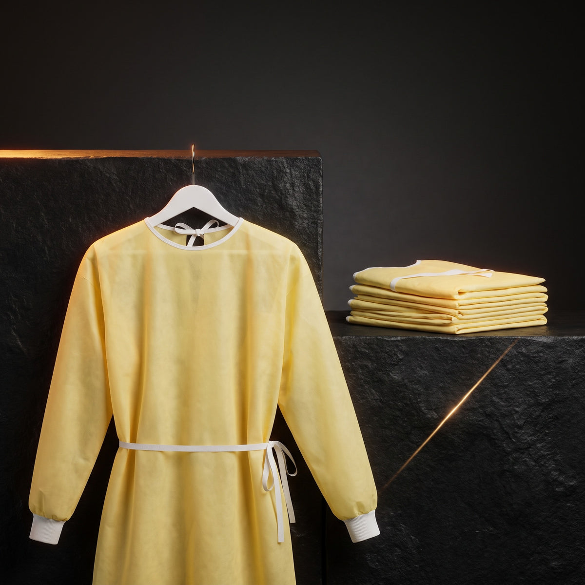 Isolation Gown, AAMI Level 2, Non-Surgical — studio hero on dark charcoal